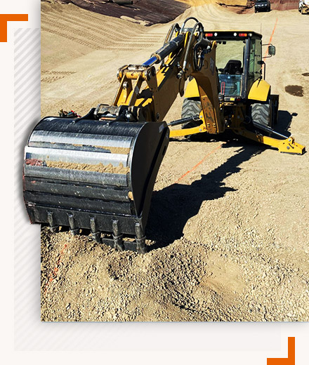 Excavator backhoe loader performing grading and excavation on a construction site in California